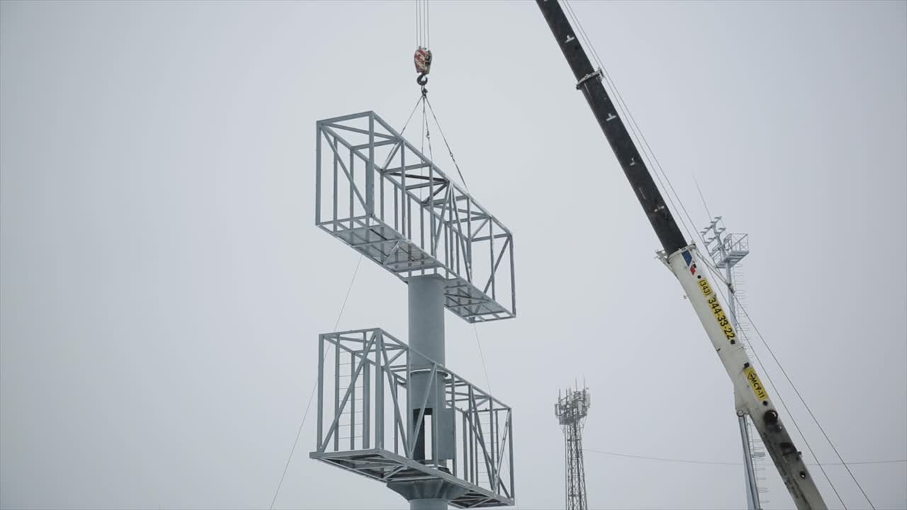 겨울에 크레인으로 야외 광고판을 설치하는 것