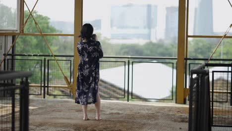 woman on a balcony overlooking a city taking a picture