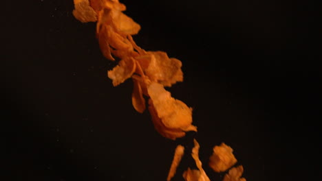 cereal flakes falling against black background