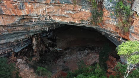 dron aéreo, carro medio, toma de la gran entrada de la cueva lapa doce de rocas coloridas con una selva tropical autónoma debajo en el parque nacional chapada diamantina en bahia, noreste de brasil