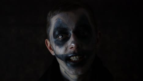 halloween makeup caucasian man talking scary performance in front of a black background dark clown