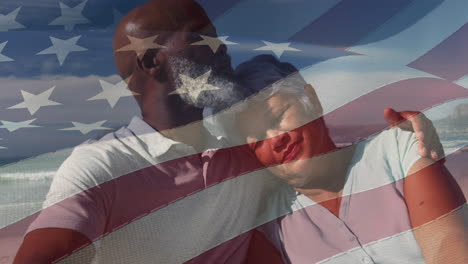 animación de la bandera de los estados unidos sobre una feliz pareja biracial enamorada abrazándose en la playa