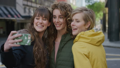 retrato de un grupo de amigas mujeres que usan una cámara de teléfono inteligente posando sonriendo tomando una foto selfie en el teléfono móvil amigas disfrutando de un divertido estilo de vida urbano en cámara lenta