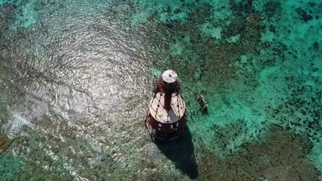 an 4k drone shot of an abandoned lighthouse, in a remote area of the caribbean sea, near bimini, bahamas