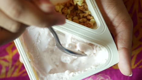 persona que come yogur cremoso con granola