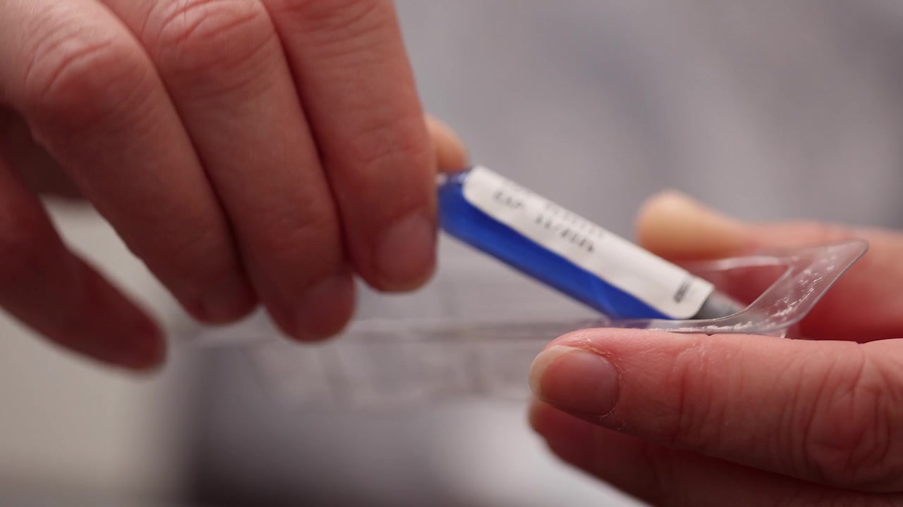 Primo piano: ago sterile della penna iniettore e capsula del farmaco vengono aperti