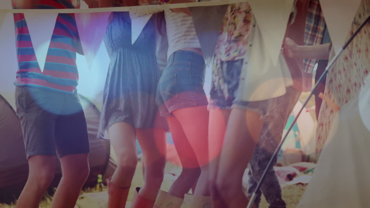 Friends dancing under bunting flags in tent, with animated business graphs floating above boots