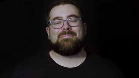 studio motion portrait of a friendly, easygoing bearded man in glasses