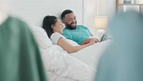 Couple,-smile-and-relax-with-tablet-in-bed