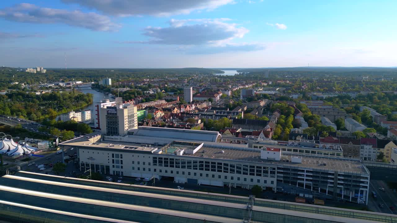 Berlin Spandau train station and Mall shopping center with surrounding urban landscape. Brilliant aerial view flight panorama overview drone