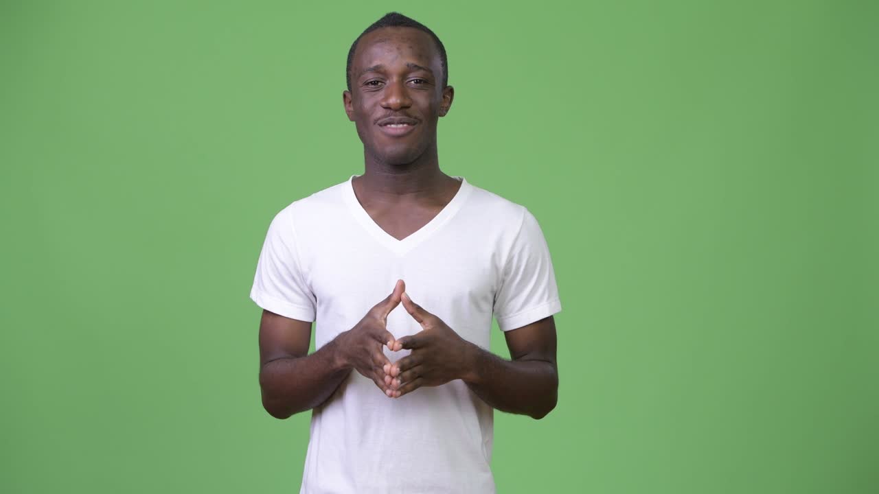 Young African man talking against green background