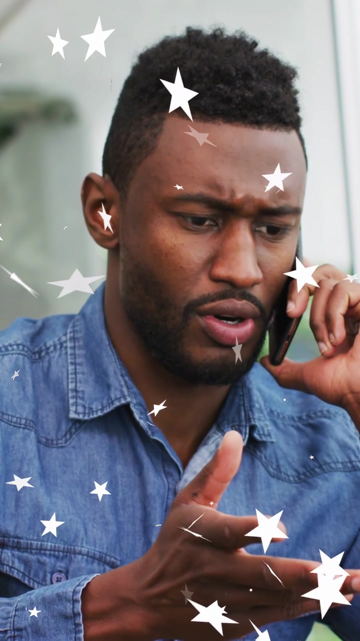 Video verticale: Uomo che risponde a una chiamata tecnica, tiene in mano un telefono e gestisce un problema, mentre delle stelle bianche gli attraversano il viso.