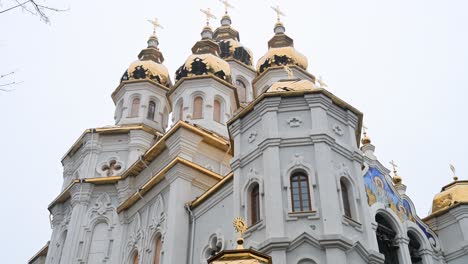 tilt-up view of the holy myrrh-bearing women church in kharkiv. the golden dome is damaged and the walls are pockmarked by shrapnel from a russian strike during the war