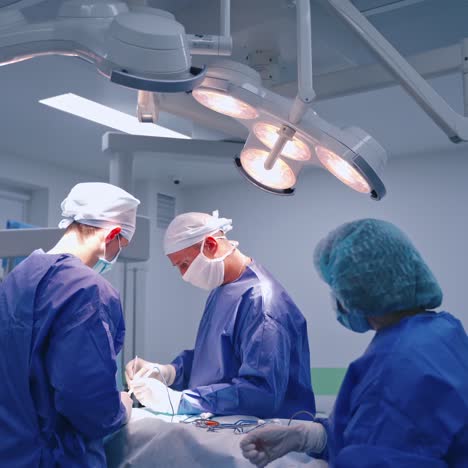 surgery process. group of surgeons doing an operation to a patient in the modern operating room. nurse assists doctors in clinic.
