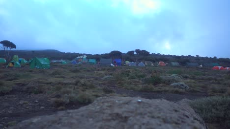 toma estática del campamento de caminata kilimajaro con carpas y gente caminando