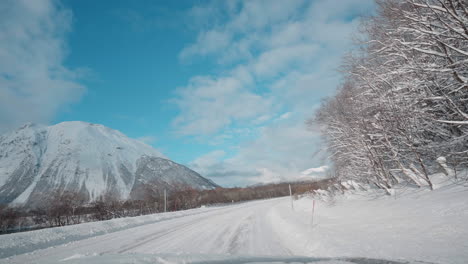 POV-driving-footage-on-snowy-mountain-roads-during-winter