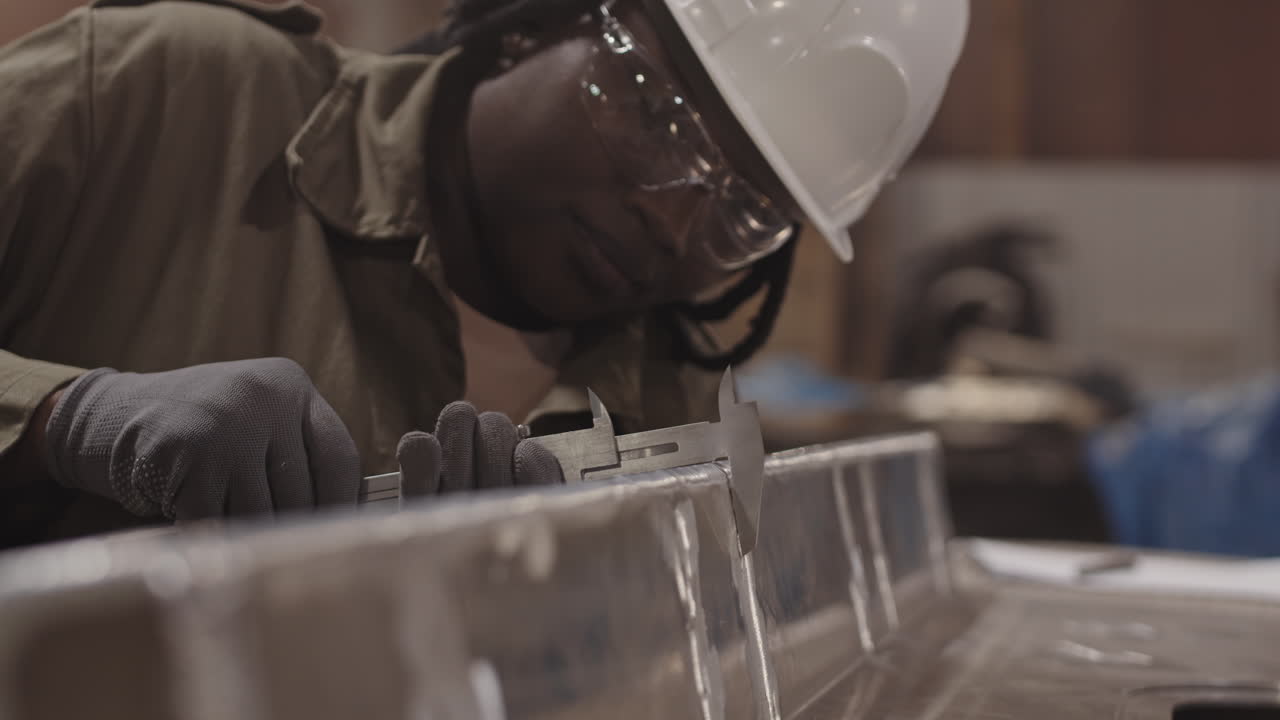 Worker Inspecting Metal Component with Caliper