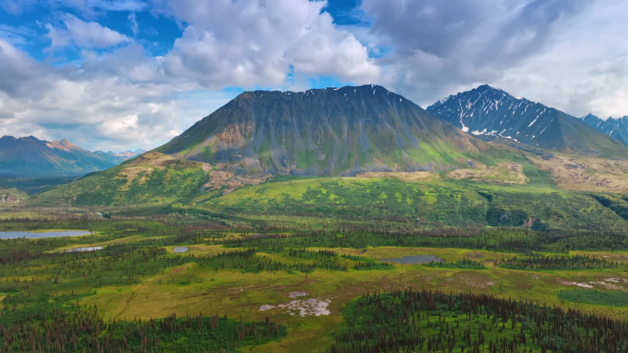 Beautiful ridged mountains with little snow on the slopes. Amazing nature of Alaska from the drone footage