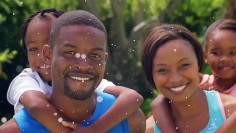 animation of white spots over happy family at birthday party