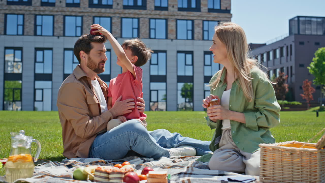 Joyful parents spending time with child boy in park. Happy family having fun