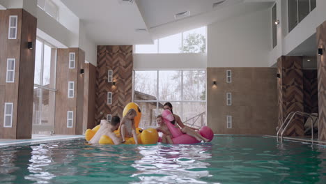 happy visitors of modern wellness center for family and children parents and kids are playing in pool