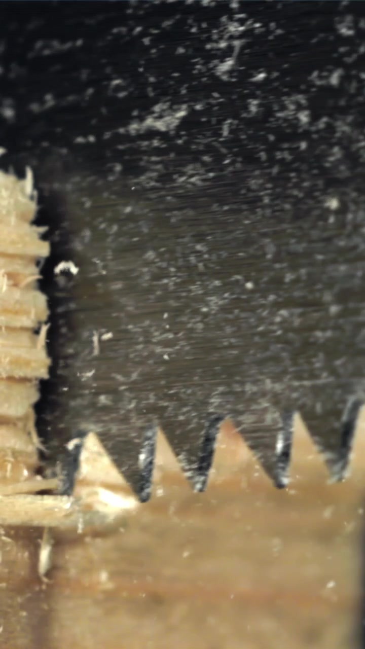 Primo Piano di Lama di Sega che Taglia Legno con Segatura Volante