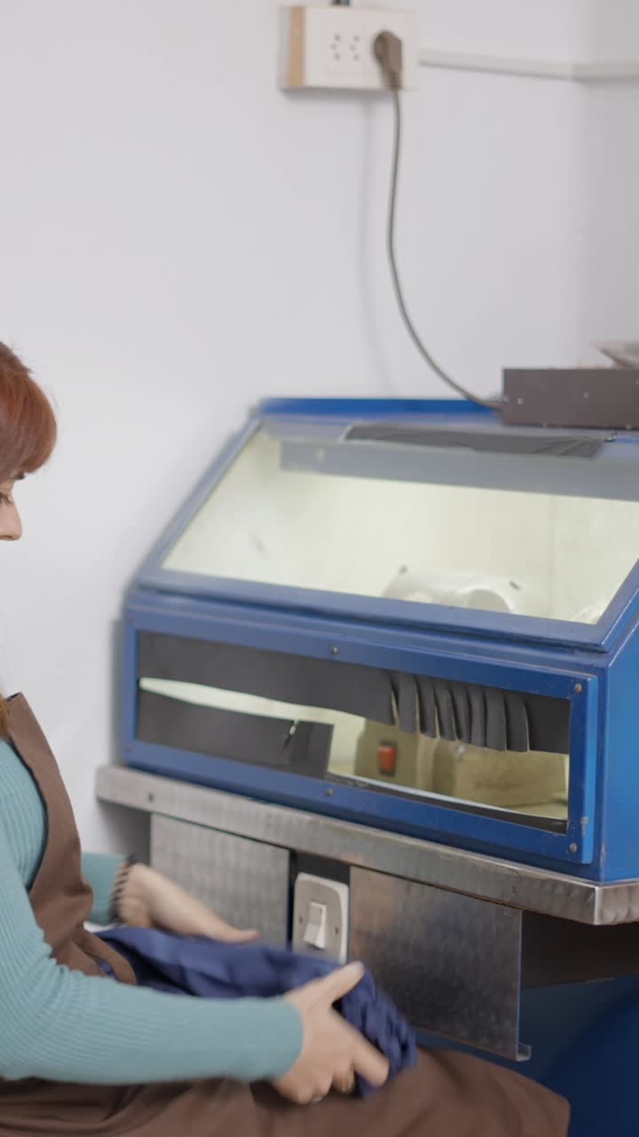 Woman working with an industrial machine in a workshop