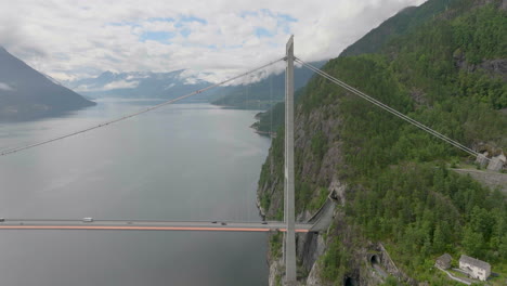 hardanger bridge with tall tower suspension design, road tunnel entering mountain, aerial