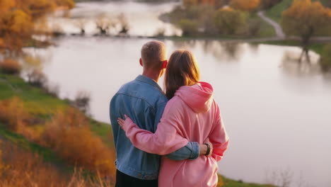 couple on walk in nature. back view of couple holding hands while walking together in park