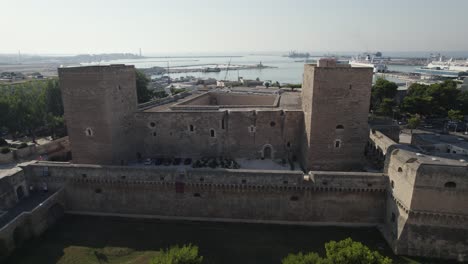 Aerial-view-of-Castello-Svevo-or-Swabian-Castle-rampart,-cruise-ship-in-the-harbor,-panoramic-cityscape