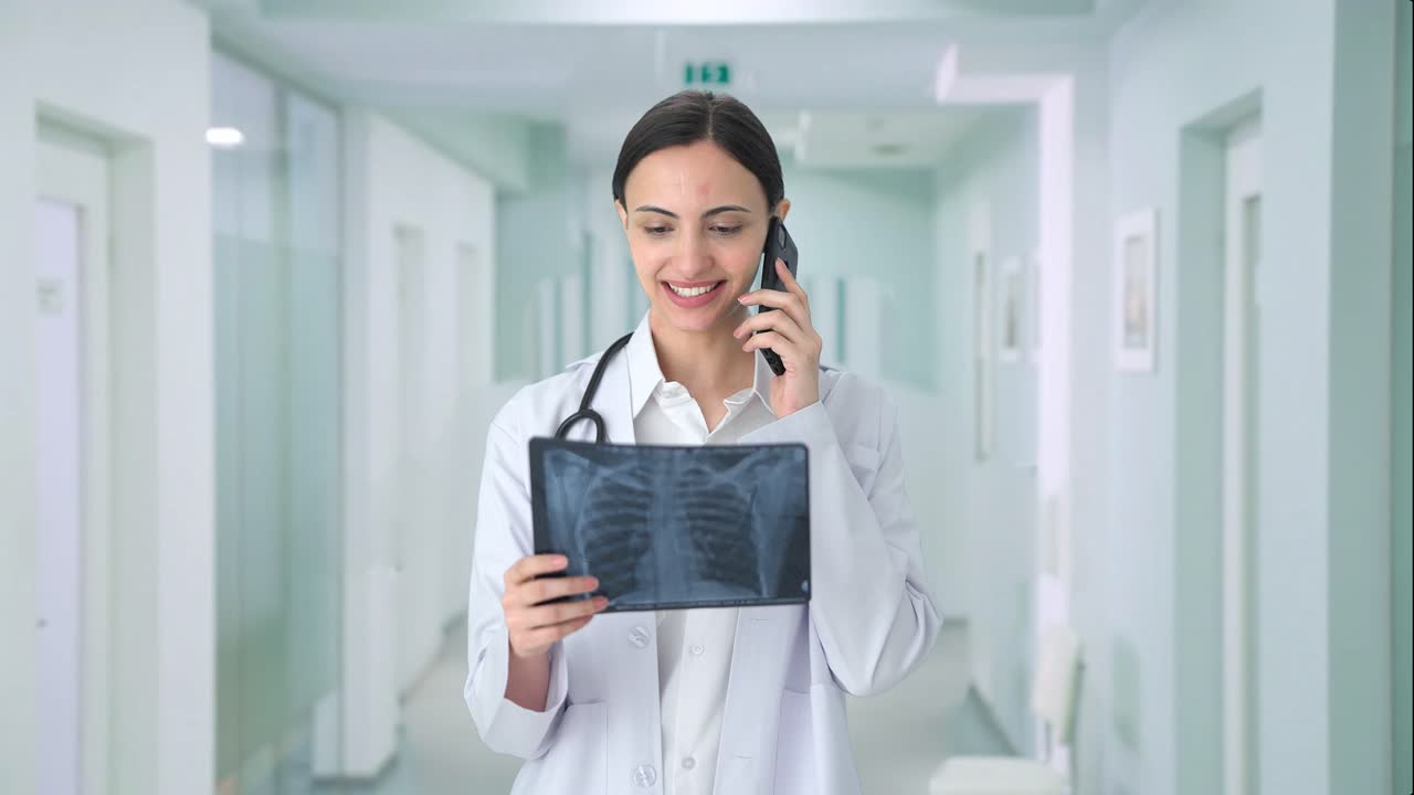 doctora india feliz explicando el informe de rayos x en la llamada
