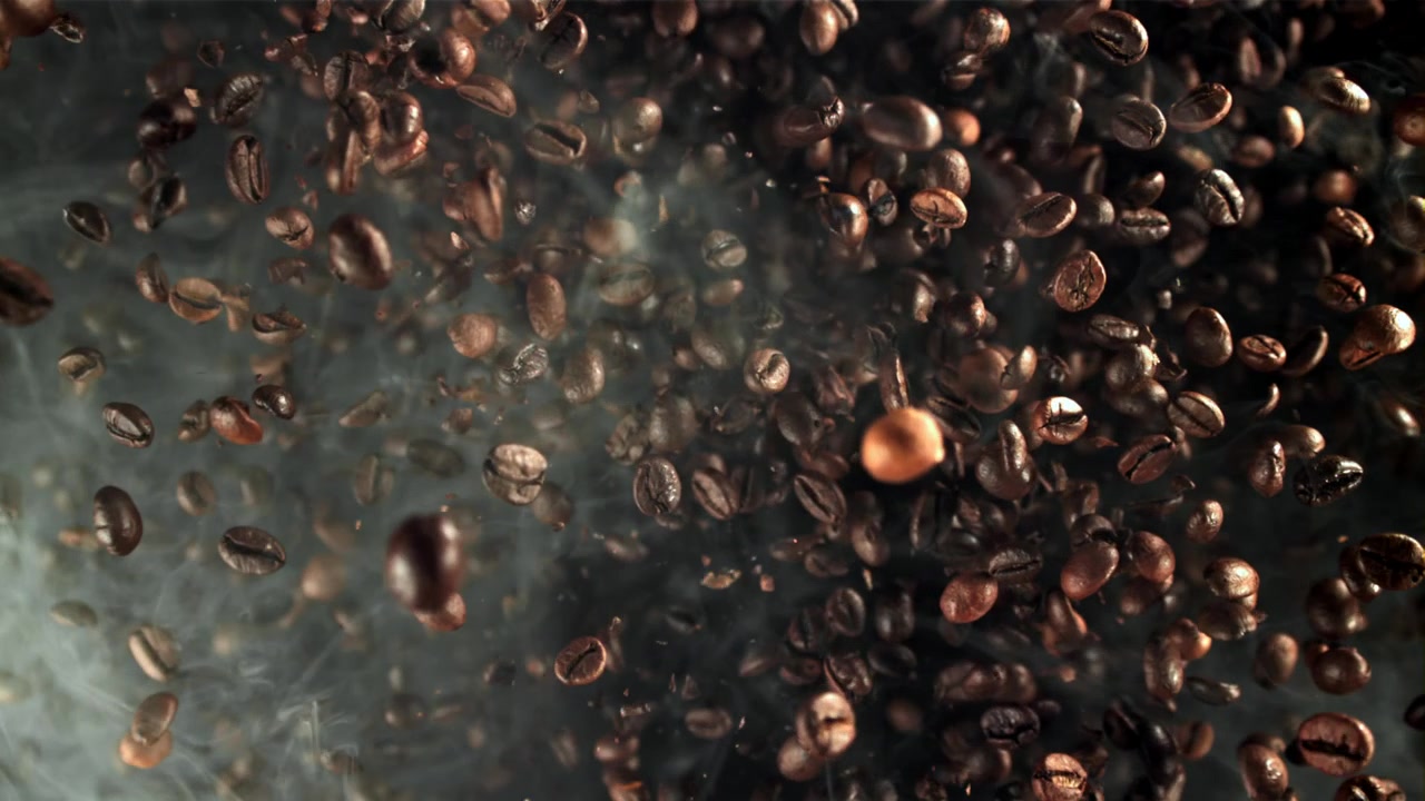 Chicchi di caffè appena tostati che cadono con fumo aromatico