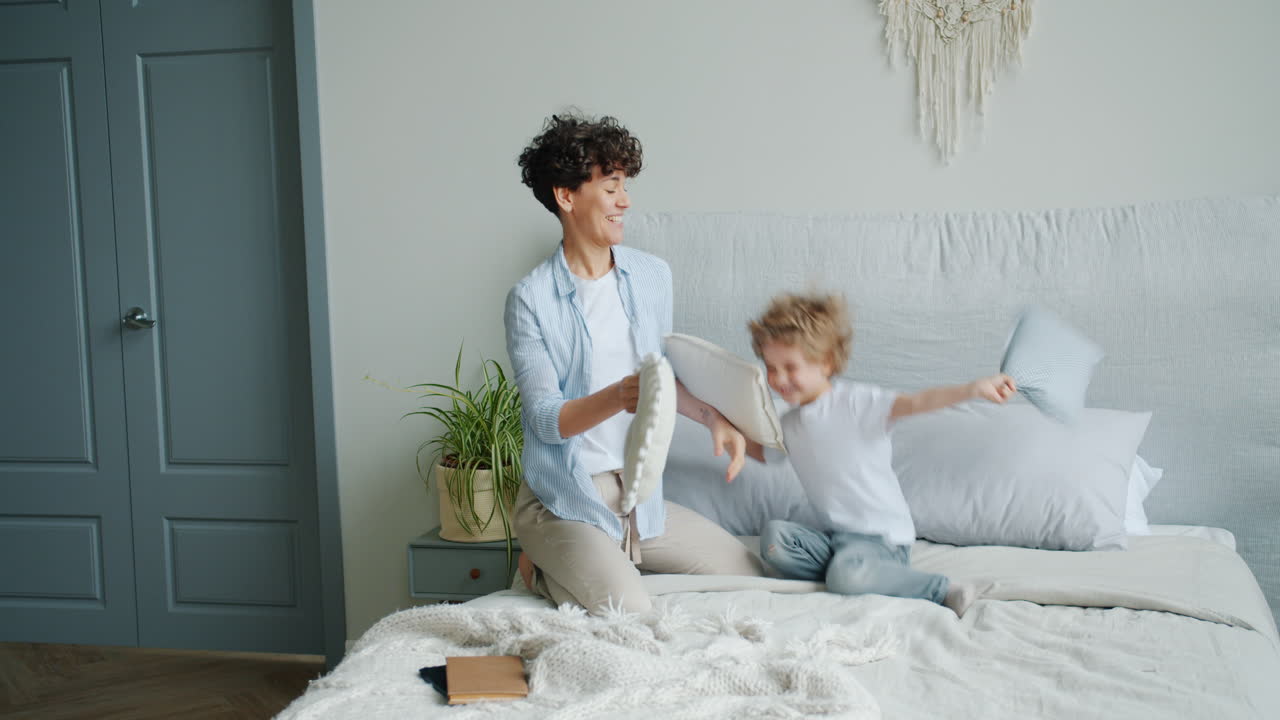 Mãe e Filho Fazendo Guerra de Travesseiros