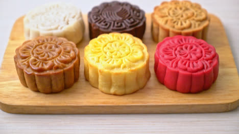 colourful chinese moon cake with mixed flavour on wood plate