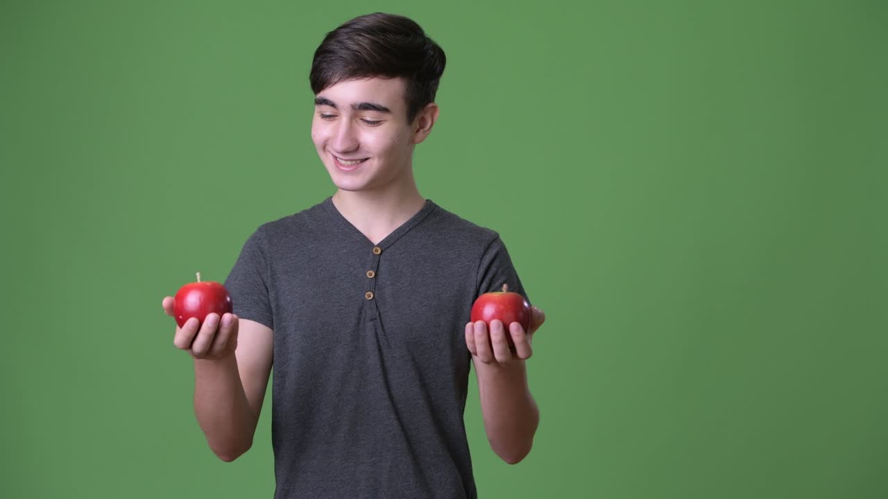 초록색 배경에 젊은 잘생긴 이란 십대 소년