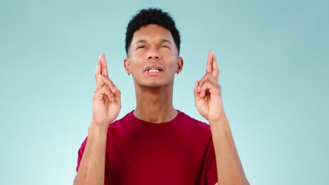 praying, face and man with fingers crossed