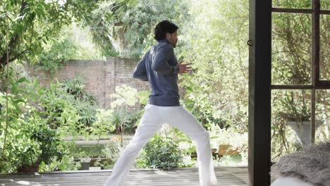 caucasian man practicing yoga on terrace in sunny nature, slow motion