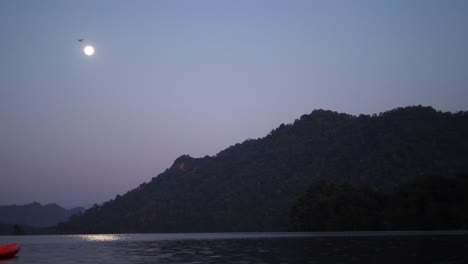 time-lapse of moon rising above serene mountain lake