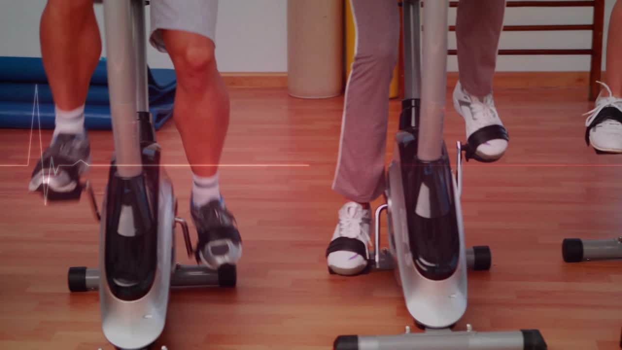 Vertical video: Three riders pedaling bikes in gym, low cut showing ECG line tracking cadence