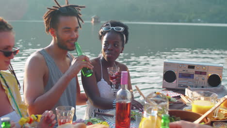 happy friends enjoying lake dinner party