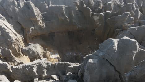 Water-splashing-out-of-blowholes-during-a-sunny-day-at-Punakaki-Pancake-Rocks,-West-Coast,-New-Zealand