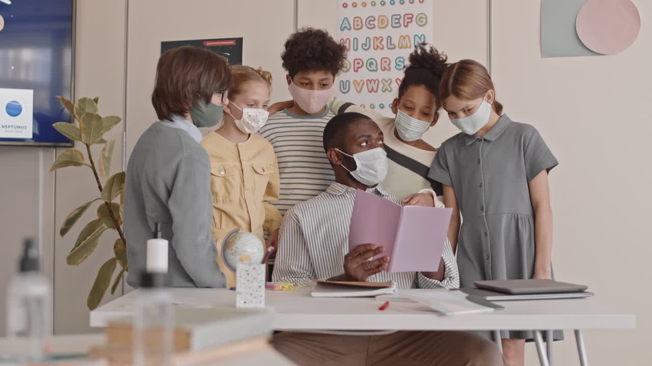 Schoolchildren Standing at Teacher Table during Lesson