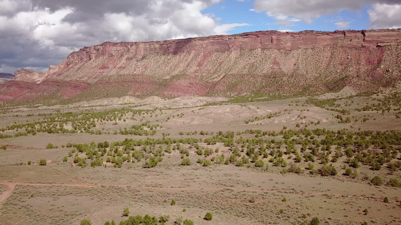 antena de camino de tierra con butte mesa flat top mountain en un hermoso día en el desierto suroeste de colorado, ee.uu.