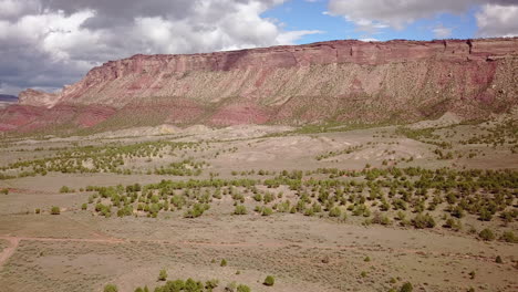 Antenne-Der-Unbefestigten-Straße-Mit-Butte-Mesa-Flat-Top-Mountain-An-Einem-Schönen-Tag-In-Der-Wüste-Im-Südwesten-Von-Colorado,-USA