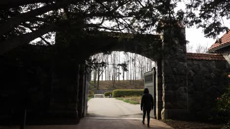 Woman-walks-through-gate-at-Biltmore-House-in-Asheville,-North-Carolina