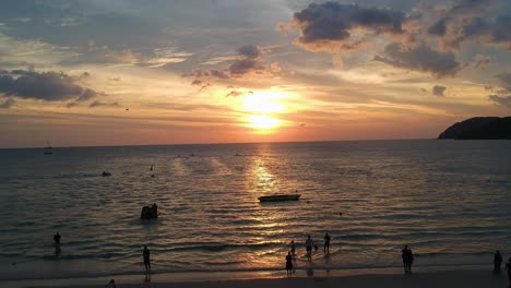 flying drone from left to right while beautiful sunset reflecting in the ocean at pantai cenang in langkawi malyasia