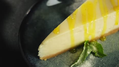 a piece of lemon sweet dessert on a plate on a black background.