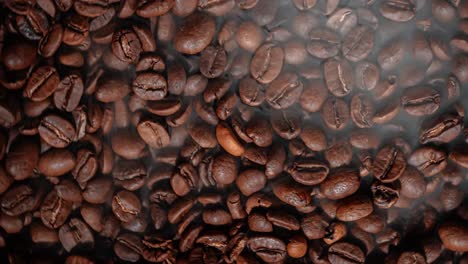 Close-up-of-seeds-of-coffee.-Fragrant-coffee-beans-are-roasted-smoke-comes-from-coffee-beans.