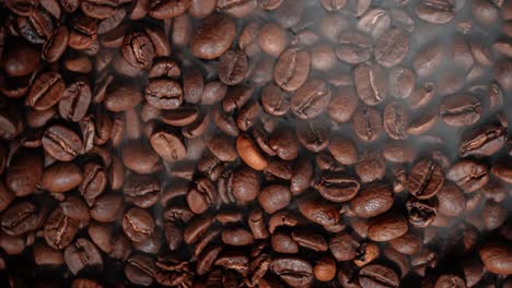 cerca de las semillas de café. los granos de café perfumados son tostados el humo viene de los granos de café.