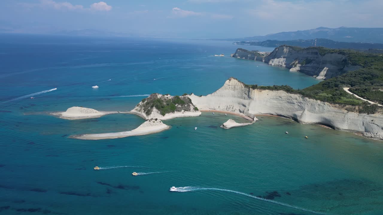 Drone shots reveal a stunning white rocky hill formation, with bustling boats cruising around its base, offering a vibrant contrast between natural beauty and lively activity.